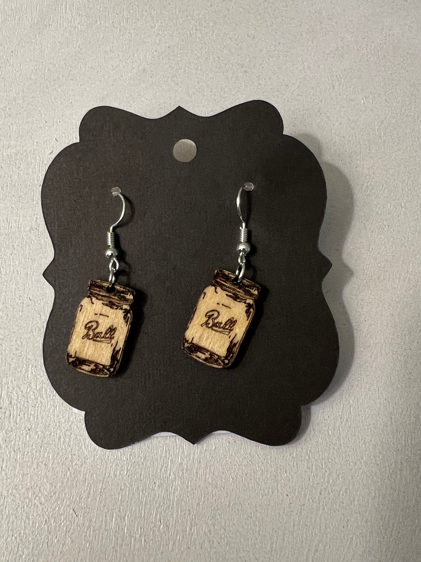 Pair of earrings on a black card with a gray background