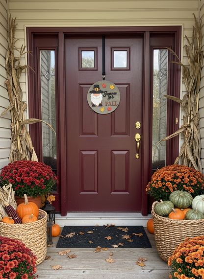 Decorative front door with fall-themed decorations including pumpkins, mums, and a sign.