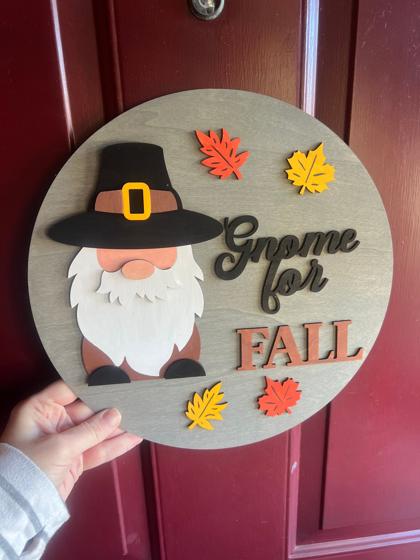Decorative sign with 'Gnome for Fall' and autumn leaves on a wooden background