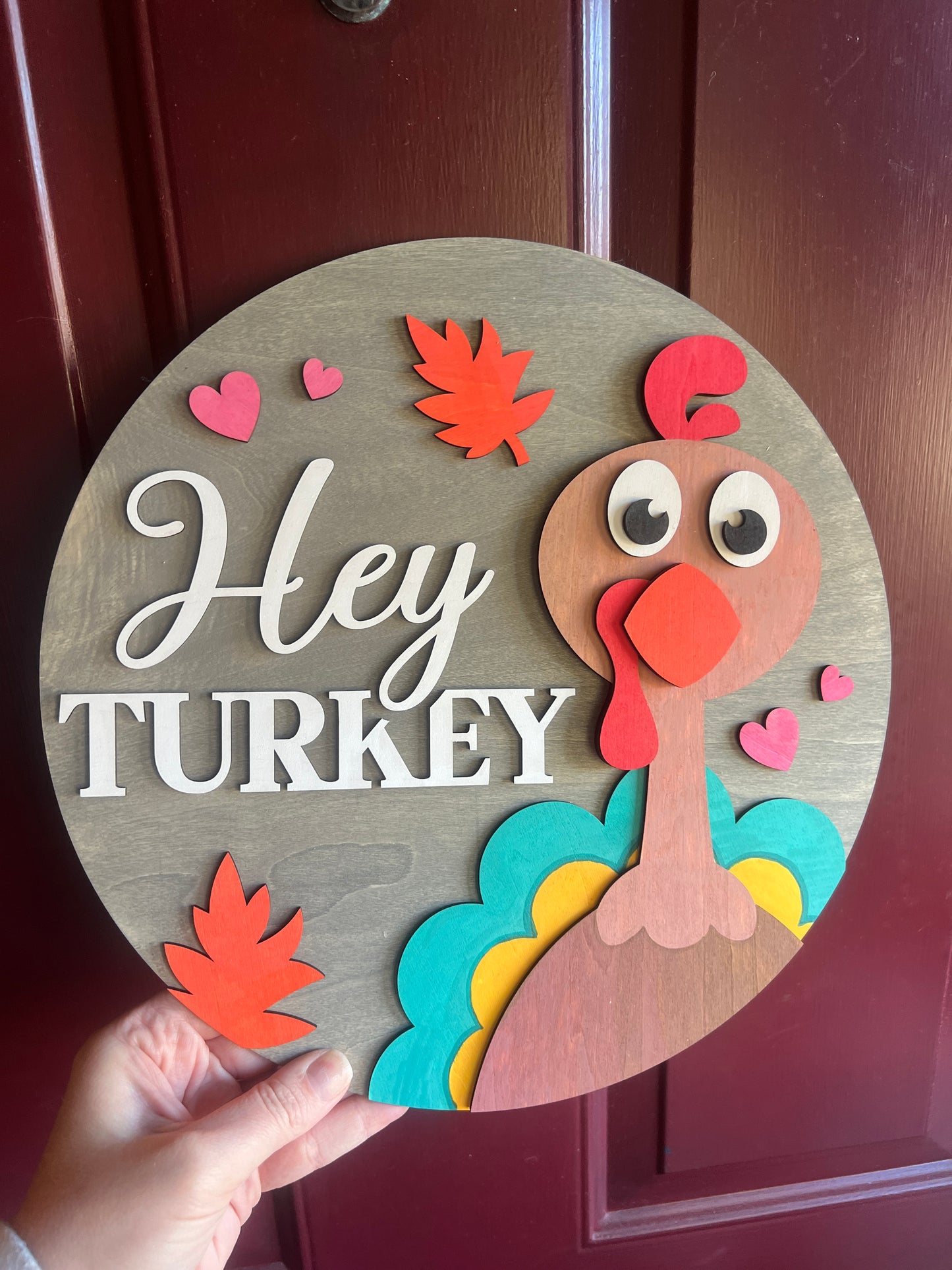 Decorative sign with a turkey design and 'Hey Turkey' text on a wooden background.