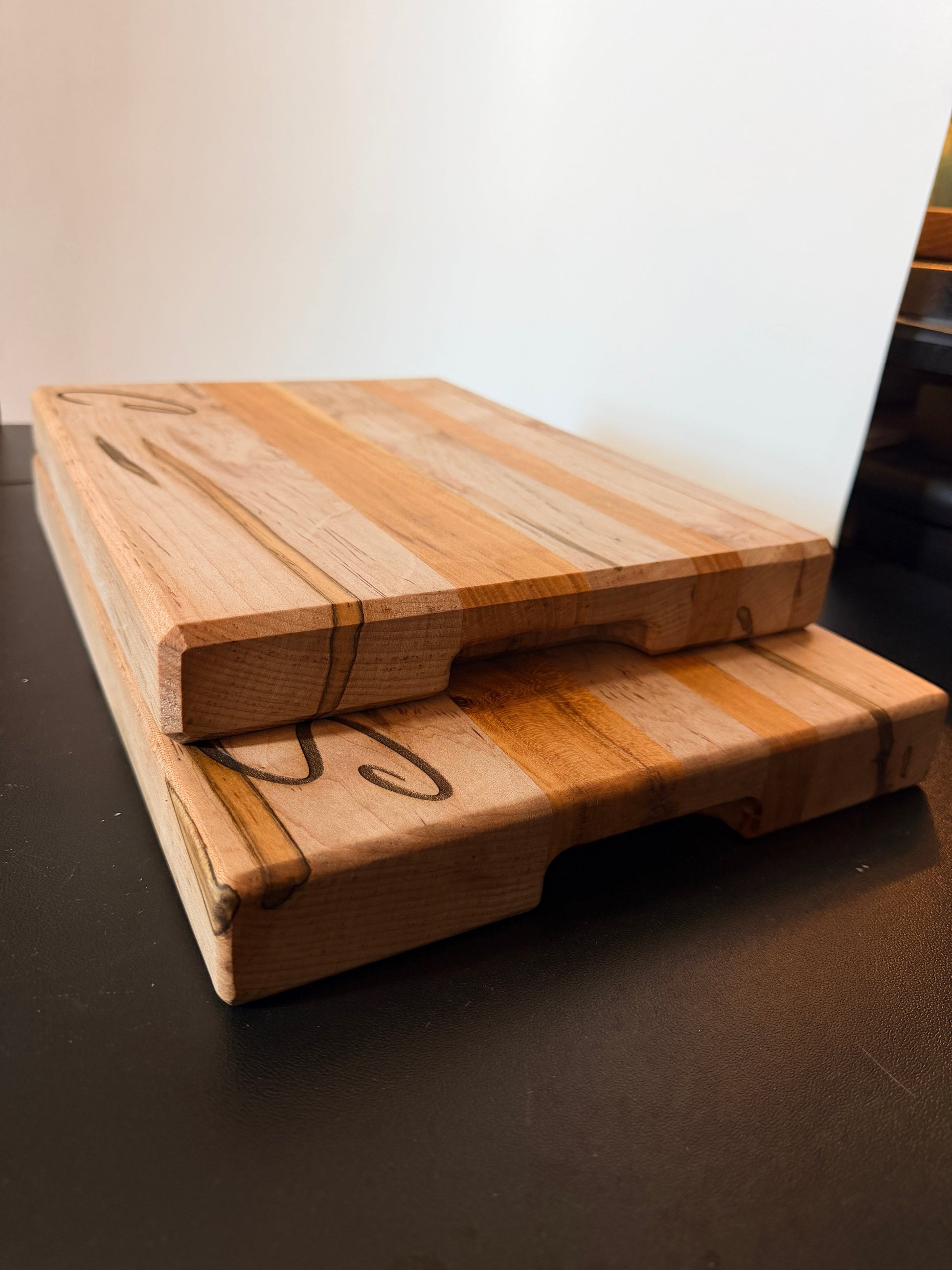 Side view of ambrosia maple and cherry cutting board showing edge grain construction and built-in side handles