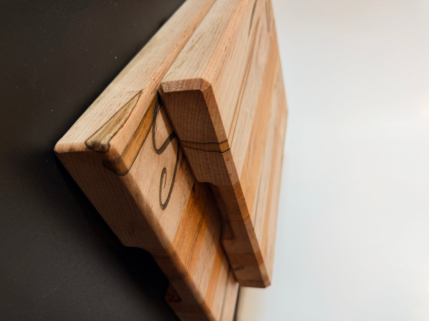 Handcrafted ambrosia maple and cherry wood cutting board with natural grain patterns and engraved initial, edge grain design with smooth finish