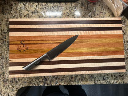 Wooden cutting board with knife on a granite countertop