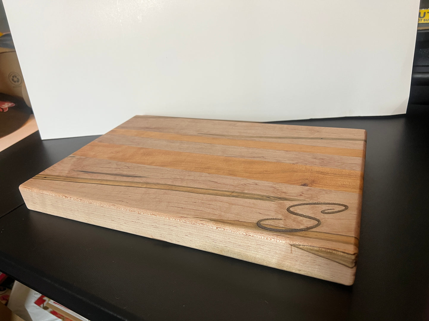Handcrafted ambrosia maple and cherry wood cutting board with natural grain patterns and engraved initial, edge grain design with smooth finish