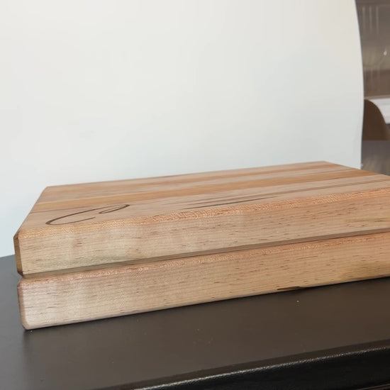 Video showing two handcrafted cutting boards made from ambrosia maple and cherry wood, displayed side by side to compare sizes, with natural wood grain, edge grain design, and integrated side handles