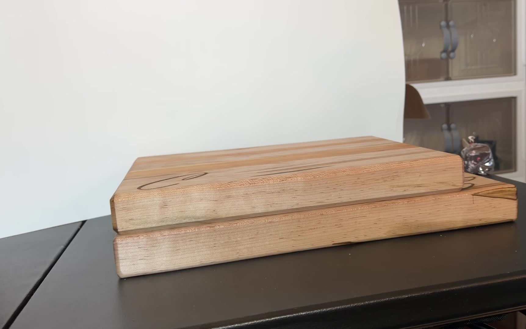 Video showing two handcrafted cutting boards made from ambrosia maple and cherry wood, displayed side by side to compare sizes, with natural wood grain, edge grain design, and integrated side handles